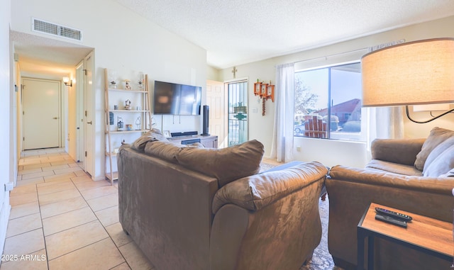 tiled living room featuring lofted ceiling and a textured ceiling