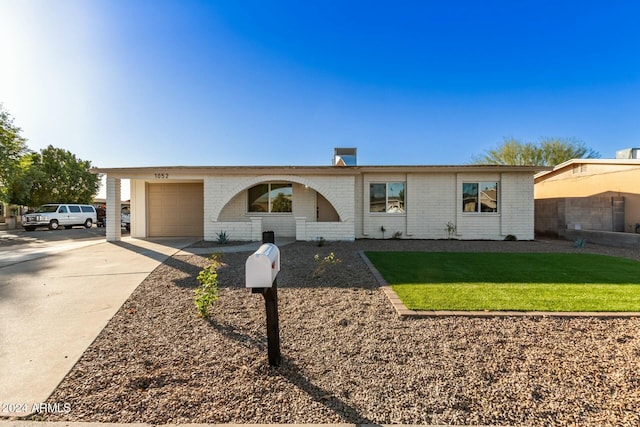 ranch-style home featuring a front yard and a garage