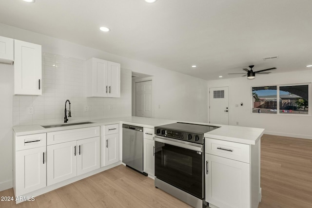 kitchen featuring kitchen peninsula, sink, light hardwood / wood-style flooring, and appliances with stainless steel finishes