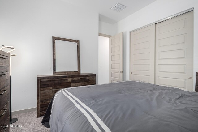 bedroom with a closet and light carpet