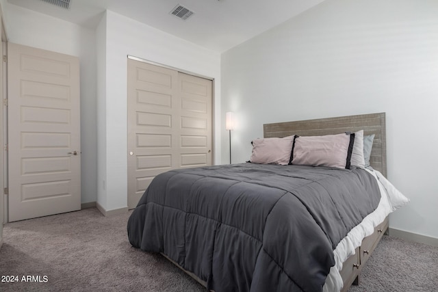 bedroom with lofted ceiling, a closet, and carpet flooring