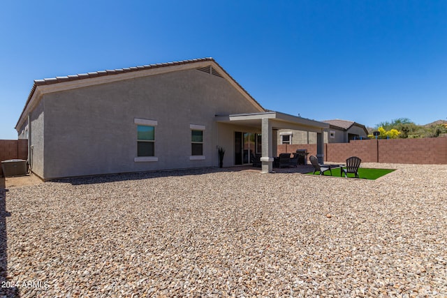 back of property featuring a patio, an outdoor living space, and central air condition unit