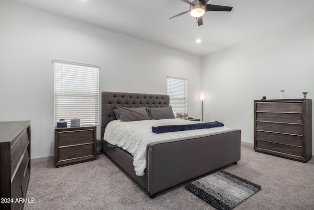 bedroom with light carpet, multiple windows, and ceiling fan