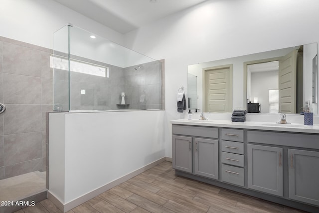 bathroom featuring a healthy amount of sunlight, double sink vanity, and wood-type flooring