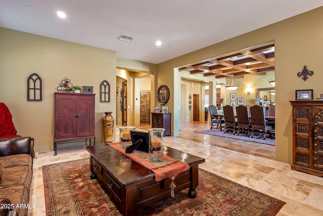 living room featuring beamed ceiling, coffered ceiling, visible vents, and stone tile floors