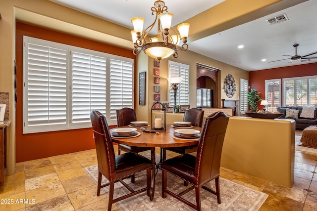 dining room featuring ceiling fan with notable chandelier, recessed lighting, visible vents, and stone tile floors