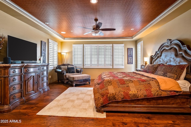 bedroom with ornamental molding, a raised ceiling, dark wood-type flooring, and recessed lighting