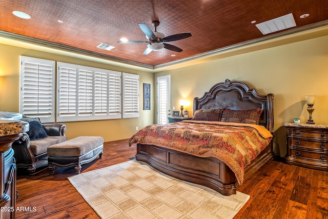 bedroom featuring visible vents, wood finished floors, and ornamental molding