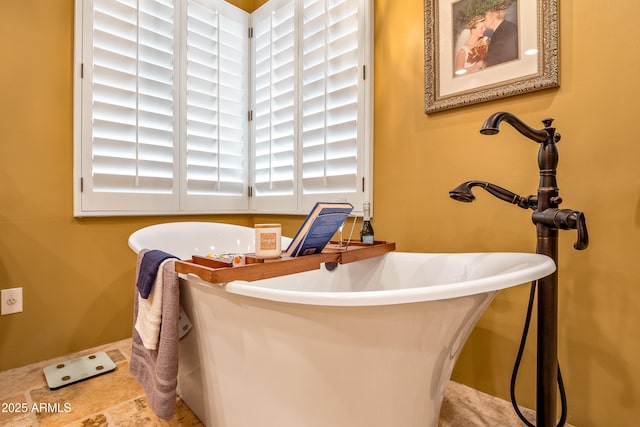 full bath featuring a freestanding bath and a healthy amount of sunlight