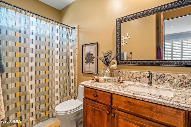 bathroom featuring a shower with shower curtain, vanity, and toilet