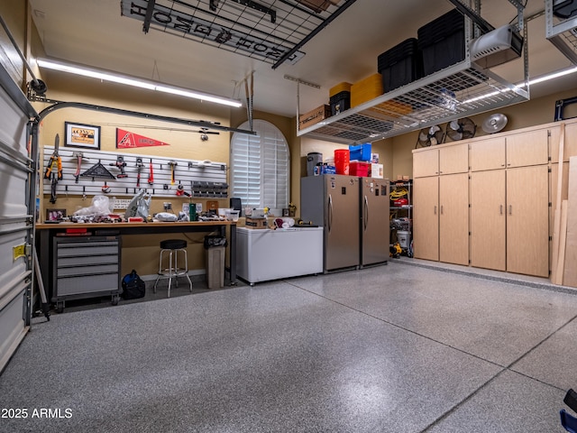 garage featuring a workshop area and freestanding refrigerator