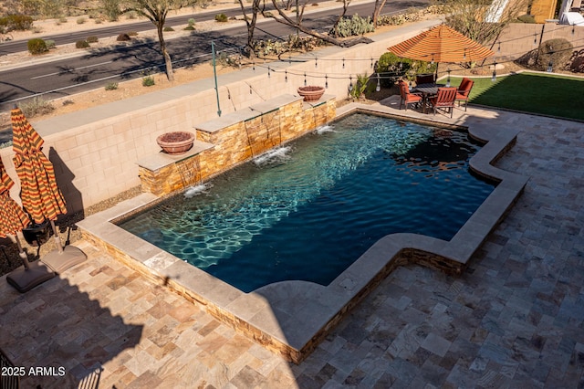 view of swimming pool featuring a patio area, fence, and a fenced in pool