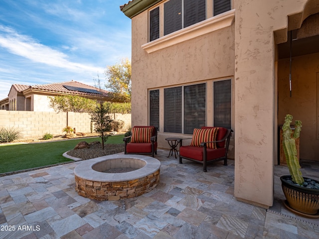 view of patio with a fire pit and fence