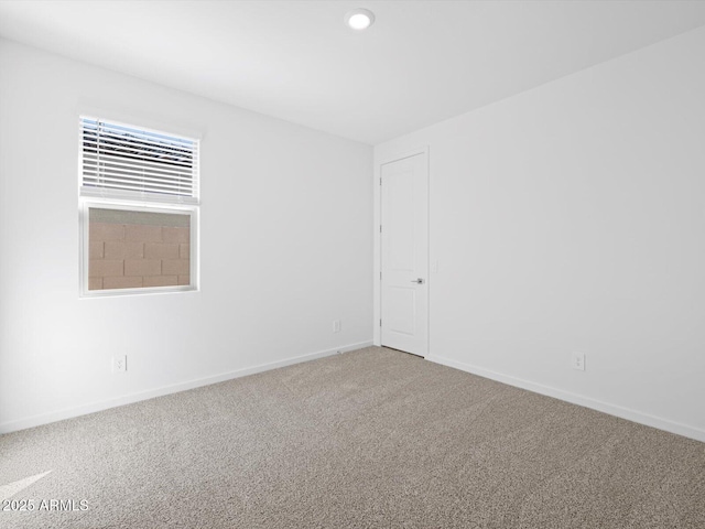 carpeted empty room featuring baseboards