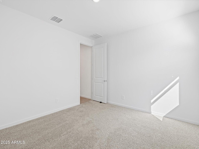 carpeted spare room with visible vents and baseboards