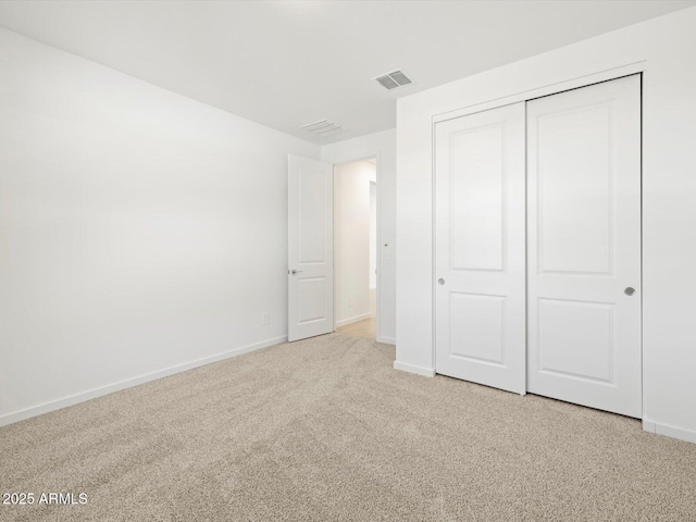 unfurnished bedroom with carpet floors, a closet, visible vents, and baseboards