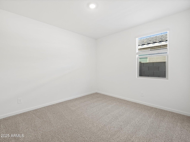 spare room featuring carpet flooring and baseboards