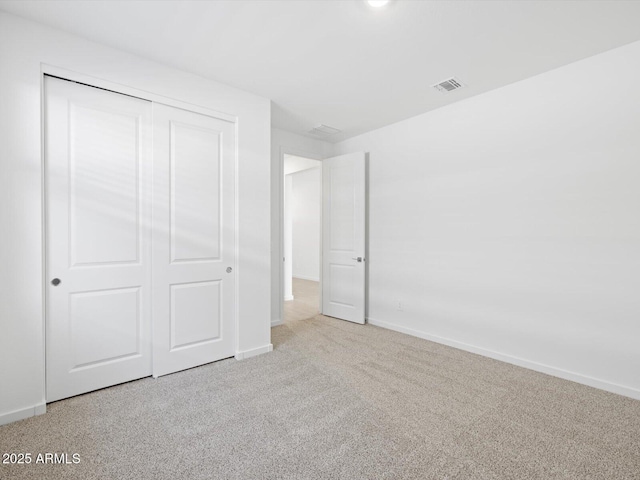 unfurnished bedroom featuring baseboards, carpet, visible vents, and a closet