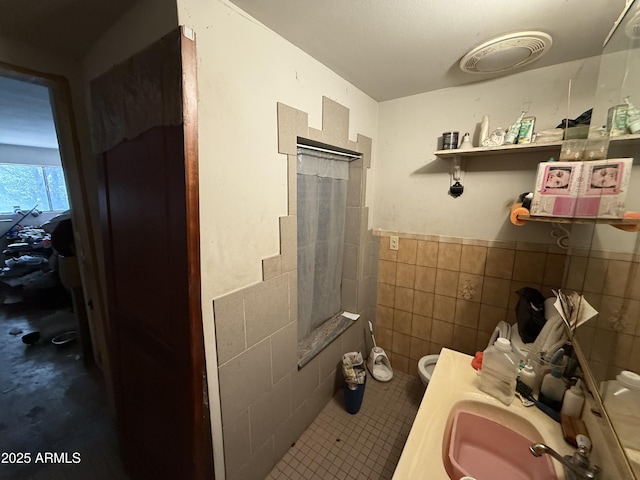 2030 N 21st Pl, Phoenix, AZ 85006 - bathroom with tile walls, a shower, tile patterned flooring, a wainscoted wall, and a bidet