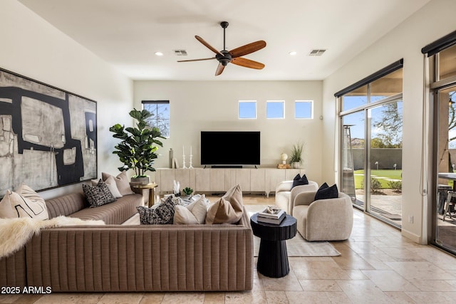 living room featuring visible vents, stone tile flooring, and recessed lighting