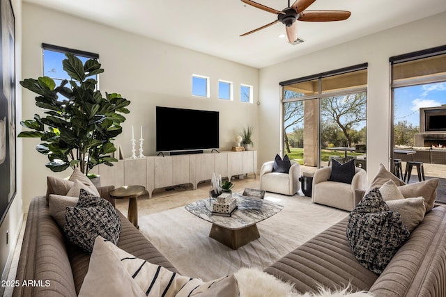 living area featuring visible vents and ceiling fan