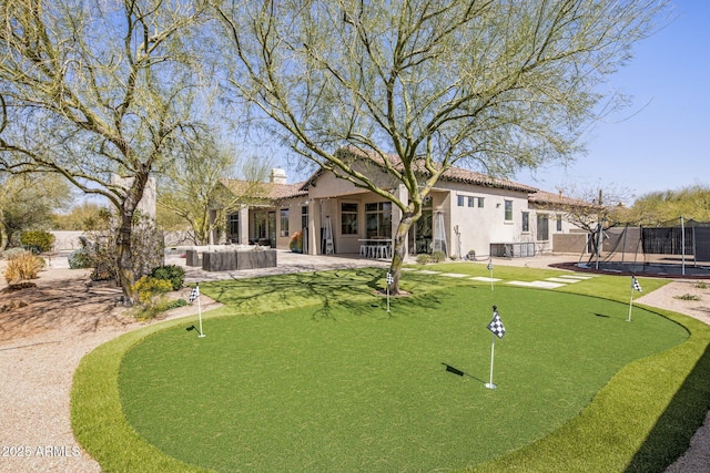 view of property's community with a patio, a trampoline, and fence