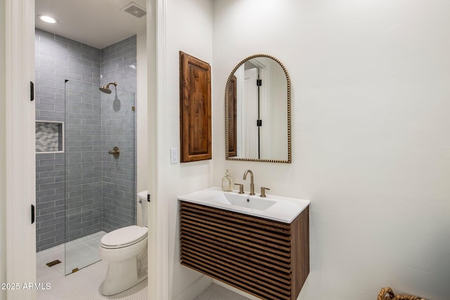 bathroom with toilet, a stall shower, visible vents, and vanity