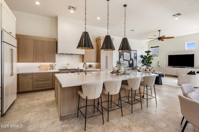 kitchen with tasteful backsplash, open floor plan, visible vents, and a spacious island