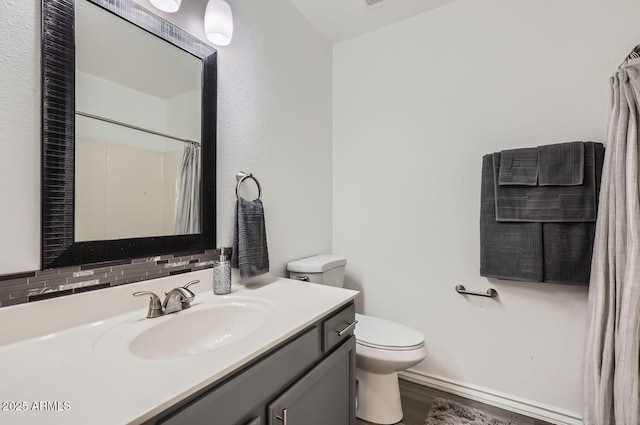 bathroom featuring toilet, curtained shower, wood finished floors, and vanity