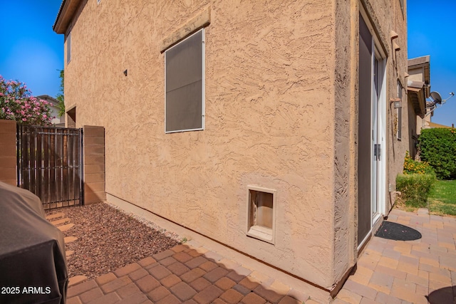 4043 E Carla Vista Dr, Gilbert, AZ 85295 - view of property exterior with stucco siding, a patio area, fence, and a gate