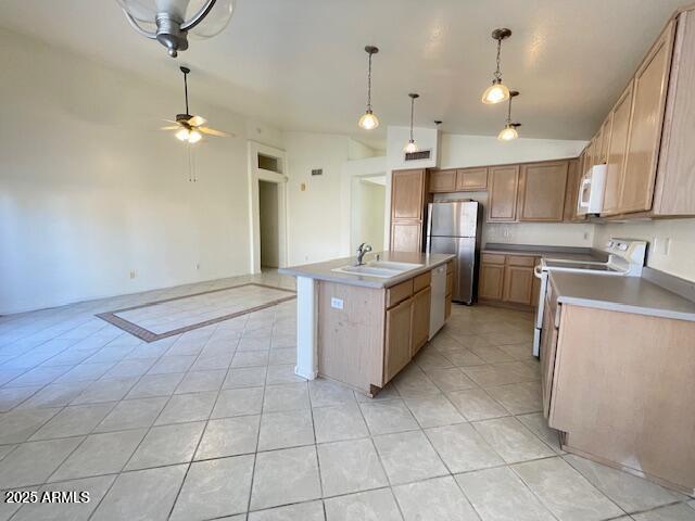 kitchen with sink, stainless steel fridge, electric range, an island with sink, and vaulted ceiling