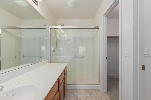 bathroom featuring tile patterned flooring, vanity, and a shower with door