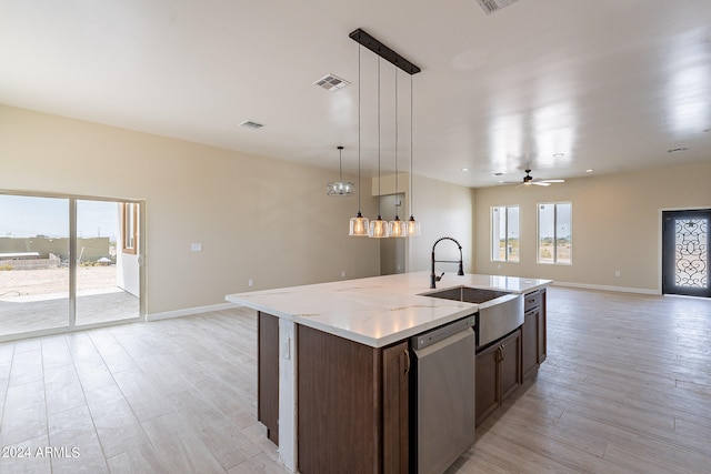 kitchen with a kitchen island with sink, sink, decorative light fixtures, light wood-type flooring, and stainless steel dishwasher