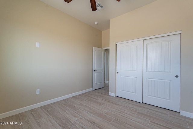 unfurnished bedroom with light hardwood / wood-style floors, a closet, and ceiling fan