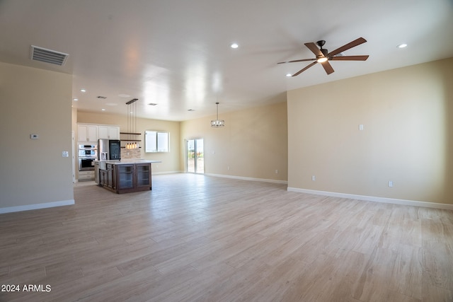 unfurnished living room featuring light hardwood / wood-style flooring and ceiling fan