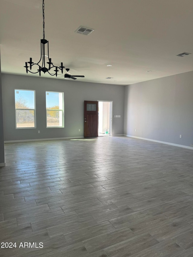 empty room featuring an inviting chandelier and hardwood / wood-style floors