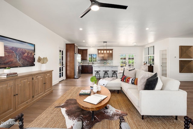 living room with french doors, ceiling fan, and light wood-type flooring