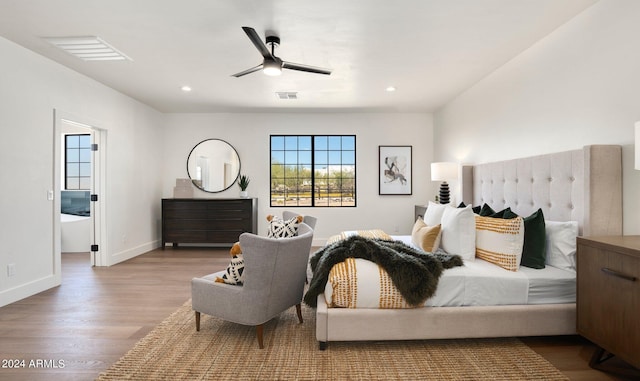 bedroom featuring ensuite bath, ceiling fan, and hardwood / wood-style floors