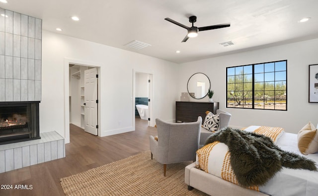 living room with ceiling fan, hardwood / wood-style floors, and a fireplace