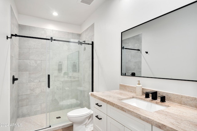 bathroom with a shower with door, vanity, and toilet