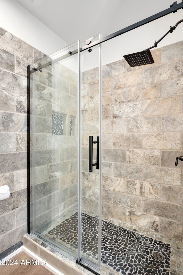 bathroom with a shower with door