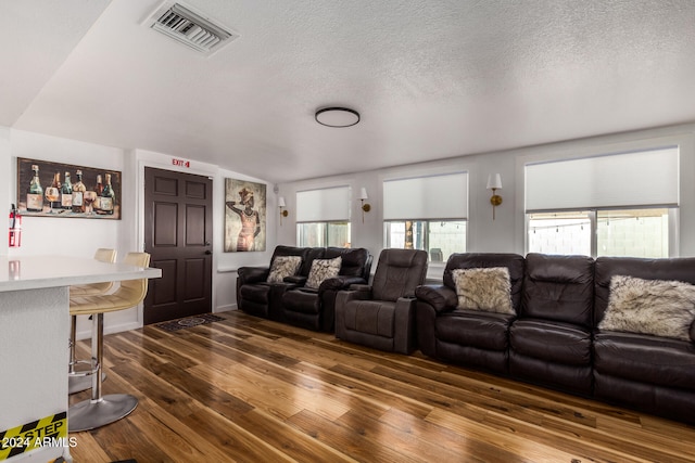 home theater featuring a textured ceiling and dark hardwood / wood-style floors