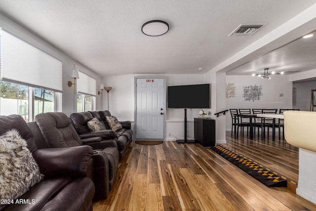 living room featuring hardwood / wood-style floors, a textured ceiling, and a chandelier