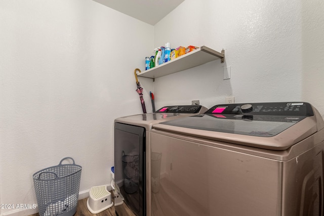 clothes washing area with wood-type flooring and washer and dryer