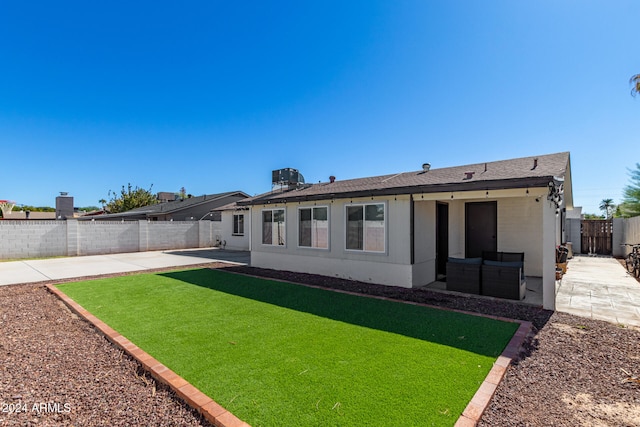 rear view of property featuring a yard, cooling unit, a patio, and an outdoor living space