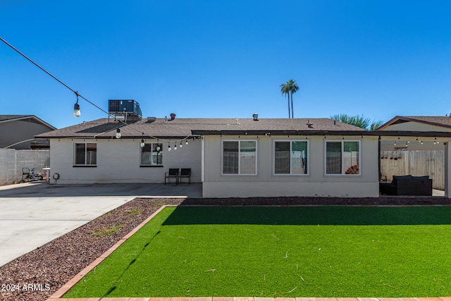 back of property with cooling unit, a lawn, and a patio area