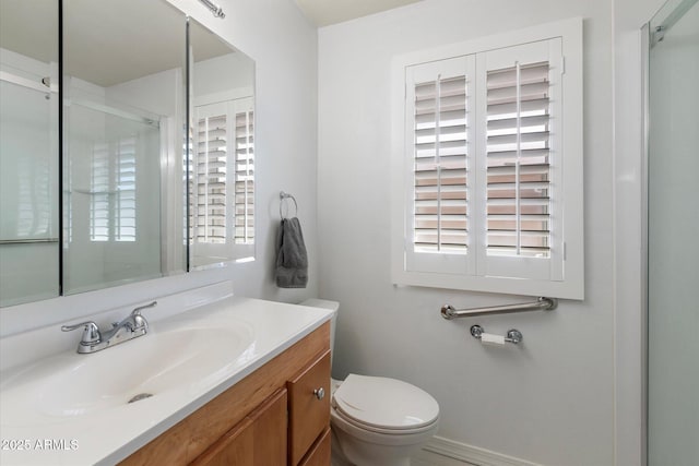 bathroom featuring vanity, toilet, and a shower with shower door