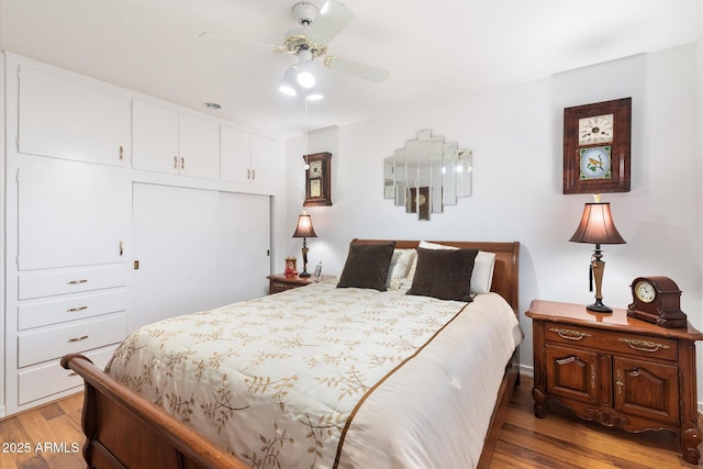 bedroom with light hardwood / wood-style floors, a closet, and ceiling fan