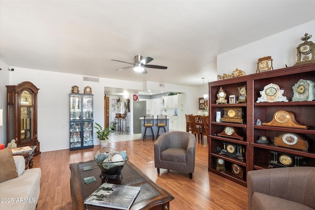 living room with ceiling fan and light wood-type flooring