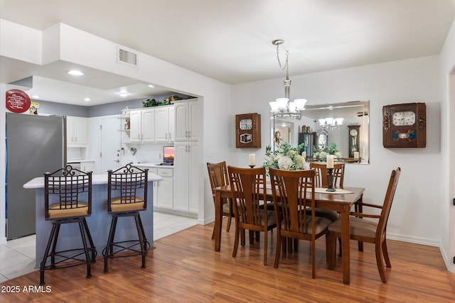 dining room featuring a chandelier and light wood-type flooring